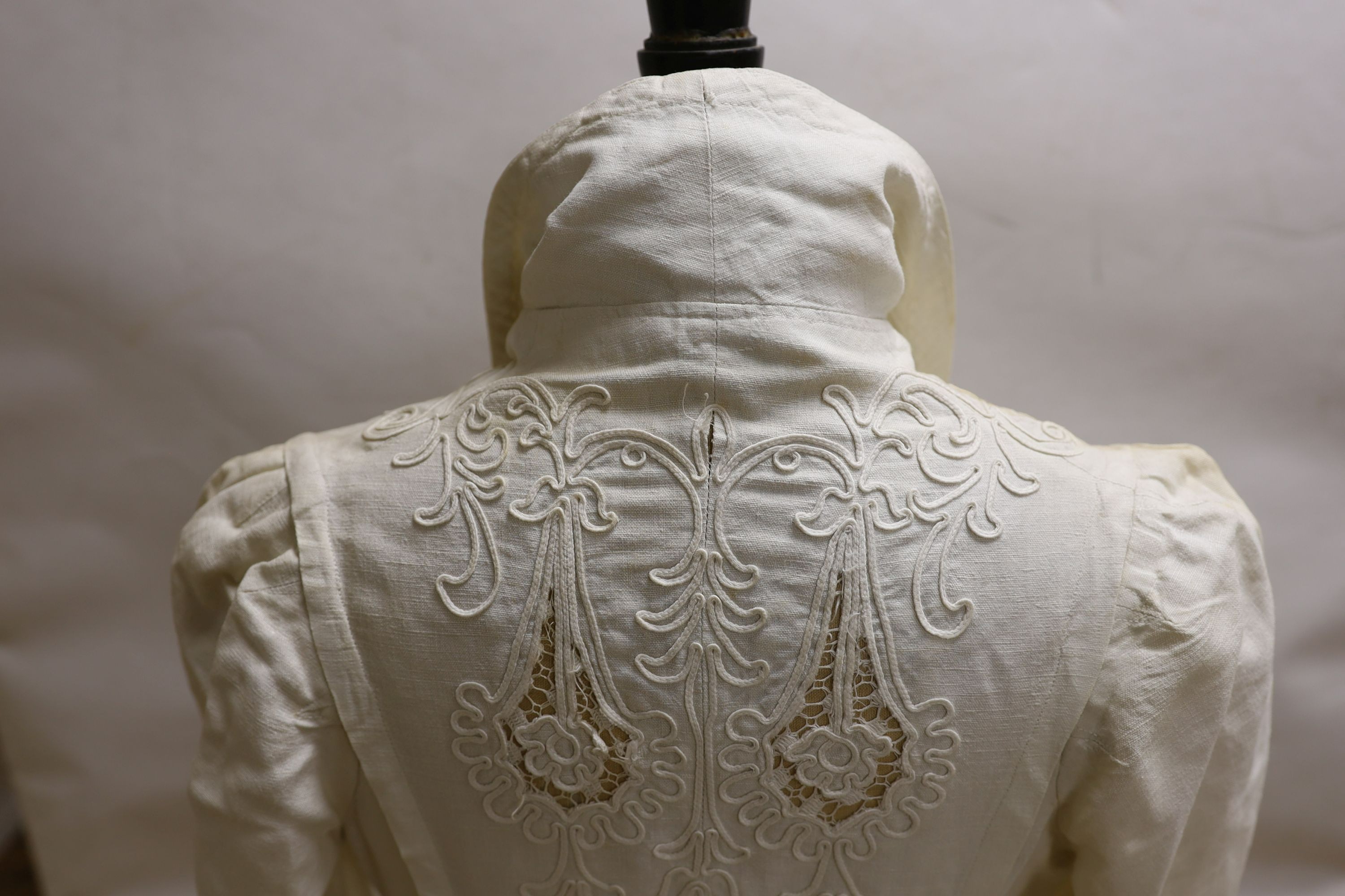 An Edwardian white/cream linen lady's coat with cut work detail and unusual button detail to the back